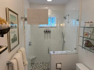 a bathroom with a shower with a glass door at La Jolla Carriage House in San Diego