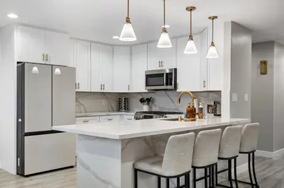 a kitchen with white cabinets and a counter with bar stools at Wellness Bnb - Your San Diego Retreat in San Diego