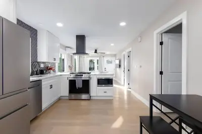 a kitchen with white cabinets and a black stove at Modern Getaway Near Downtown – Family Friendly in San Diego