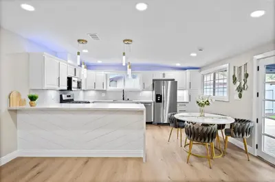a kitchen with white cabinets and a table with chairs at Exotic Home Rexview by SD Stay in San Diego