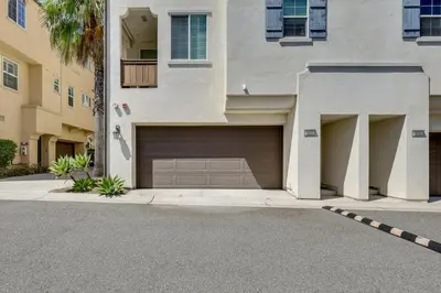 a building with a garage door and a street at Walk to Public Transit Oceanside Home with Balcony in Oceanside