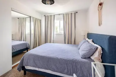 a bedroom with a blue bed and a mirror at North PB Gem Close to the Beach in San Diego