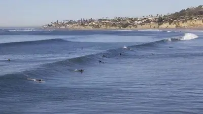 a group of people riding a wave in the ocean at North PB Gem Close to the Beach in San Diego
