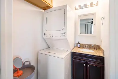 a small bathroom with a washer and dryer and a sink at North PB Gem Close to the Beach in San Diego