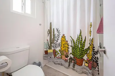 a bathroom with a shower curtain with cactus at North PB Gem Close to the Beach in San Diego