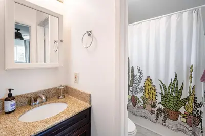 a bathroom with a sink and a shower curtain with cactus at North PB Gem Close to the Beach in San Diego