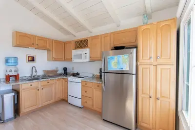 a kitchen with wooden cabinets and a stainless steel refrigerator at North PB Gem Close to the Beach in San Diego