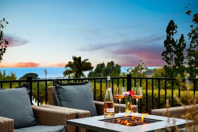 a patio with a table with a bottle of wine at Ocean View Retreat Firepit & Spacious Yard in San Diego