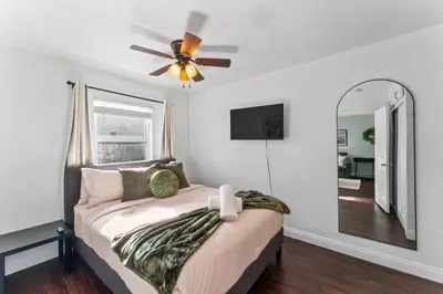 a bedroom with a bed with a ceiling fan and a mirror at Colorful & Cozy Oasis in North Park Walk to Restaurants, Bars, and Breweries in San Diego