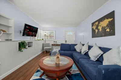 a living room with a blue couch and a table at Modern Escape, Close to Zoo, Gaslamp and Beaches in San Diego