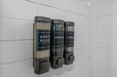 three bottles of body wash hanging on a wall at Modern Escape, Close to Zoo, Gaslamp and Beaches in San Diego