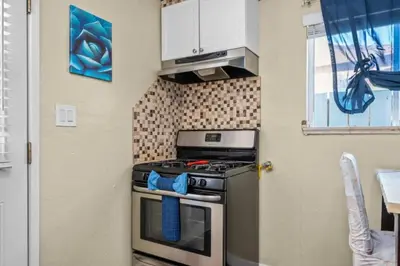 a small kitchen with a stove and a window at Modern Escape, Close to Zoo, Gaslamp and Beaches in San Diego