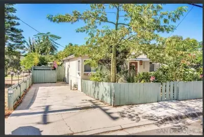 a house with a fence next to a sidewalk at Modern Escape, Close to Zoo, Gaslamp and Beaches in San Diego