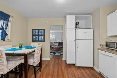 a kitchen with a table and a white refrigerator at Modern Escape, Close to Zoo, Gaslamp and Beaches in San Diego