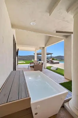a large bath tub sitting on a patio with a table at Private Gated 6BR Luxury Estate, Gym, Lake View in Escondido