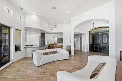 a living room with two white couches and a kitchen at Private Gated 6BR Luxury Estate, Gym, Lake View in Escondido