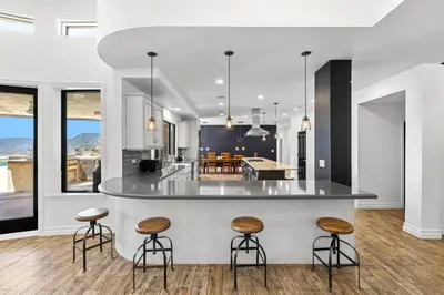 a kitchen with a bar with stools and a kitchen with a view at Private Gated 6BR Luxury Estate, Gym, Lake View in Escondido