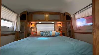 a bed in the middle of a room with two windows at Retro Star-Wagon, Ocean View at Studios in Oceanside