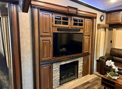 a fireplace in a living room with a large tv at Rancho CA 78 in Aguanga