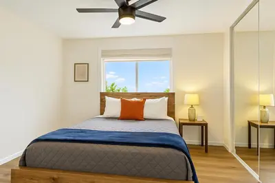 a bedroom with a bed with a ceiling fan at Sunny Coastal Escape Large 3BR Home Sleeps 8 in San Diego