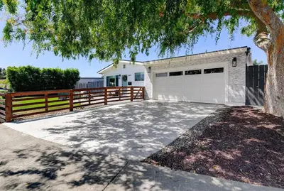 a garage with a tree and a fence at Sunny Coastal Escape Large 3BR Home Sleeps 8 in San Diego