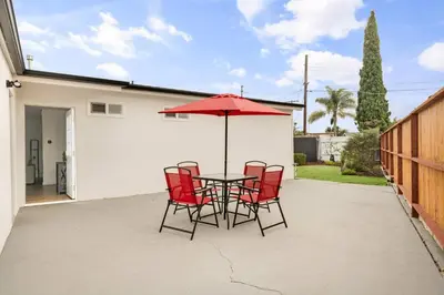 a table with chairs and an umbrella on a patio at Sunny Coastal Escape Large 3BR Home Sleeps 8 in San Diego