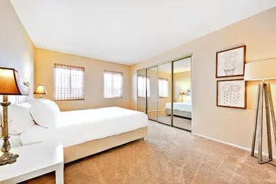 a bedroom with a large white bed and a couch at Newport Beach Simplicity II in Newport Beach