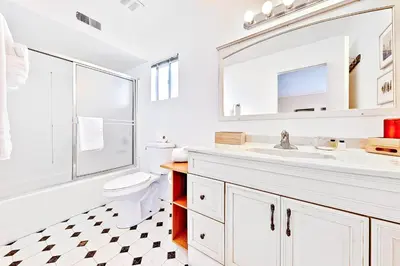 a bathroom with a sink and a toilet and a mirror at Newport Beach Simplicity II in Newport Beach