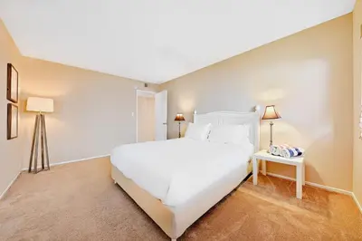 a bedroom with a large white bed and a table at Newport Beach Simplicity II in Newport Beach