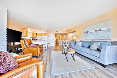 a living room with two couches and a kitchen at Newport Beach Simplicity II in Newport Beach