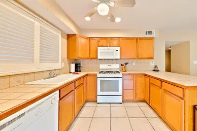 a large kitchen with wooden cabinets and white appliances at Newport Beach Simplicity in Newport Beach