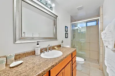 a bathroom with a sink and a toilet and a mirror at Newport Beach Simplicity in Newport Beach