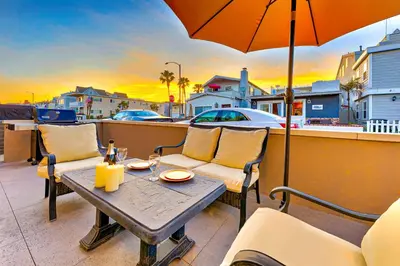 a table and chairs on a balcony with an umbrella at Newport Beach Simplicity in Newport Beach