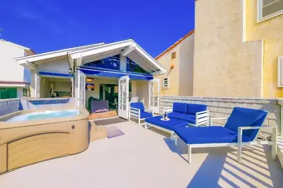 a patio with a hot tub and blue chairs at Perfect Newport Beach Location With Balcony Spa II in Newport Beach