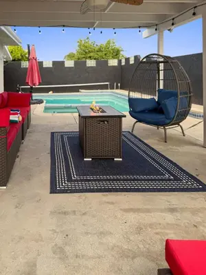 a patio with a table and a swing and a pool at Heated Pool - Jacuzzi - Firepit - Game Room in Hemet