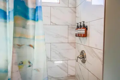 a bathroom with a shower with two bottles of alcohol at Catch of the Day Pet-Friendly El Pescador 1 Block from the Beach in San Diego