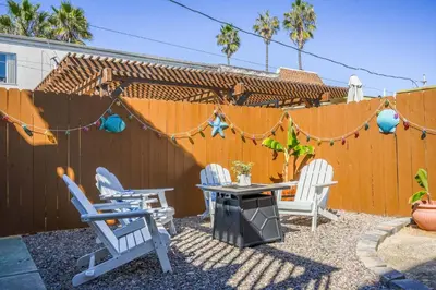 a backyard with chairs and a table and a fence at Catch of the Day Pet-Friendly El Pescador 1 Block from the Beach in San Diego