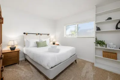 a white bedroom with a large bed and a window at Hot Tub Pool 3Bed Home in Encinitas