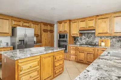 a kitchen with wooden cabinets and stainless steel appliances at Hot Tub Pool 3Bed Home in Encinitas