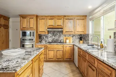 a kitchen with wooden cabinets and granite counter tops at Hot Tub Pool 3Bed Home in Encinitas