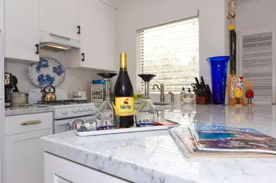 a kitchen with a counter with two bottles of wine at Charming Garden Cottage with Full Kitchen Walk to La Jolla Village & Beaches in San Diego