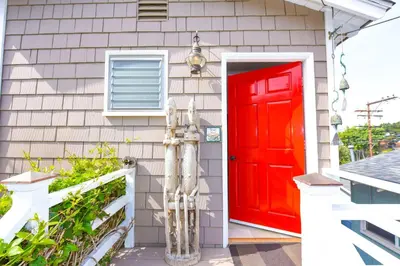 a red door on the side of a house at Charming Garden Cottage with Full Kitchen Walk to La Jolla Village & Beaches in San Diego