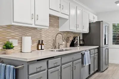 a kitchen with white cabinets and a sink at Travelers Dream Home SDSU Hot Tub Pool Table in San Diego