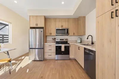 a kitchen with stainless steel appliances and wooden cabinets at Urban Villa in San Diego