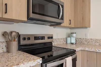a kitchen with a stove and a microwave at Urban Villa in San Diego