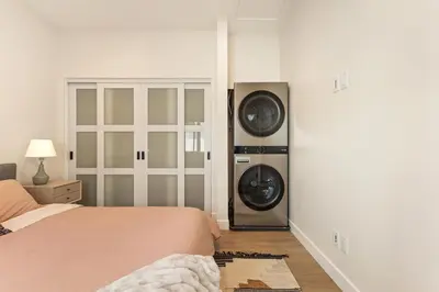 a bedroom with a washer and dryer next to a bed at Urban Villa in San Diego