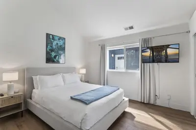 a white bedroom with a bed and a window at Steps to Lido Village and the Marina Heart of Lido Island 2 Car Garage in Newport Beach