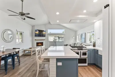 a kitchen and dining room with a ceiling fan at Steps to Lido Village and the Marina Heart of Lido Island 2 Car Garage in Newport Beach