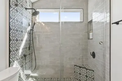 a shower with a glass door in a bathroom at Steps to Lido Village and the Marina Heart of Lido Island 2 Car Garage in Newport Beach