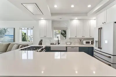 a kitchen with white cabinets and a white counter top at Steps to Lido Village and the Marina Heart of Lido Island 2 Car Garage in Newport Beach